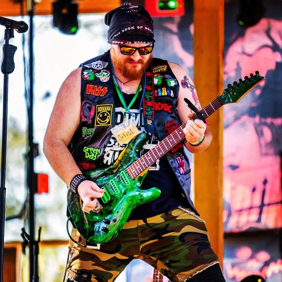ohnny Beasly playing electric guitar during a live performance