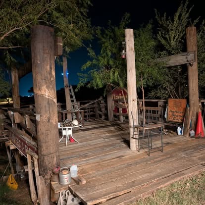 Rustic outdoor stage and deck illuminated at night at Muscle Car Ranch before TwisterFest 2026