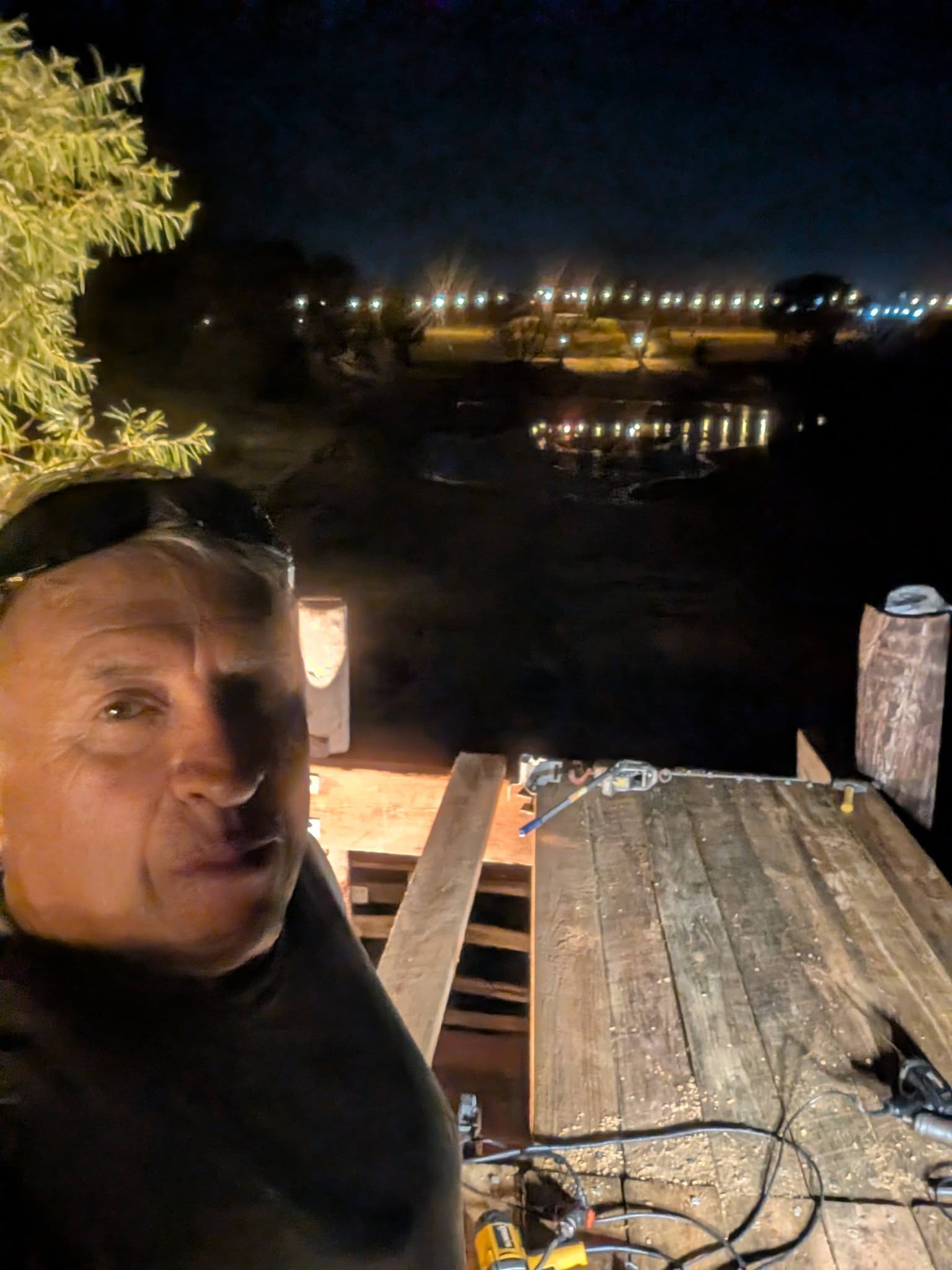 Curtis Hart building the roof above the Heavy Chevy Dock stage at Muscle Car Ranch at night