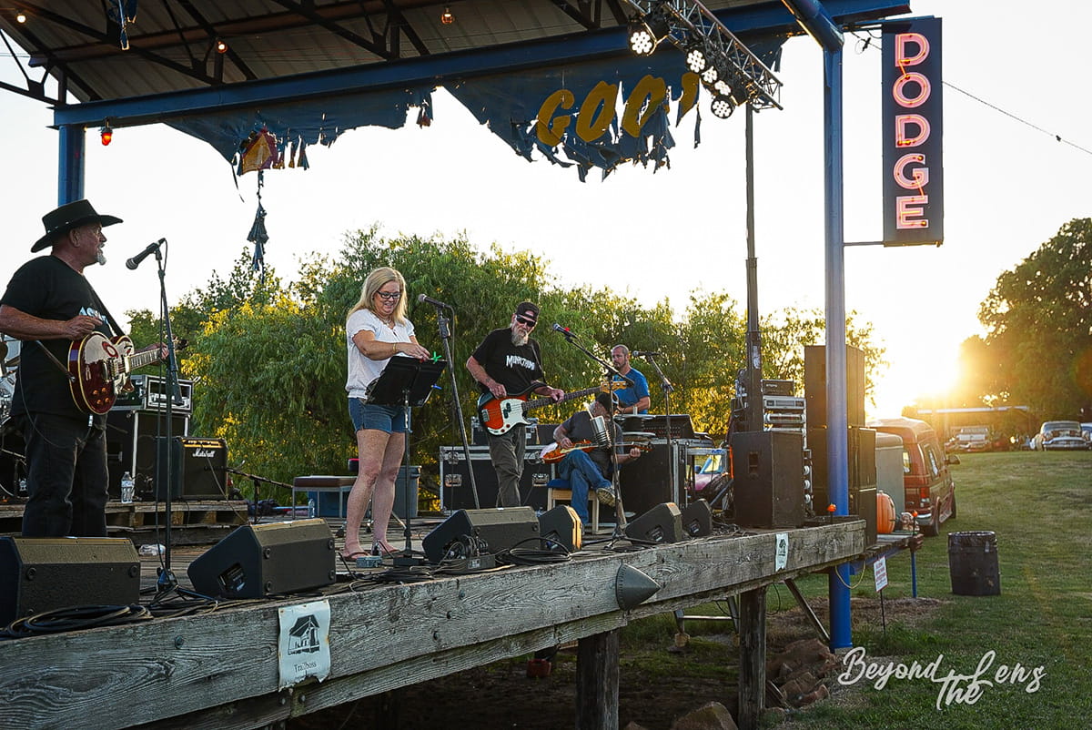 Band performing on the TwisterFest stage near a Dodge sign at sunset