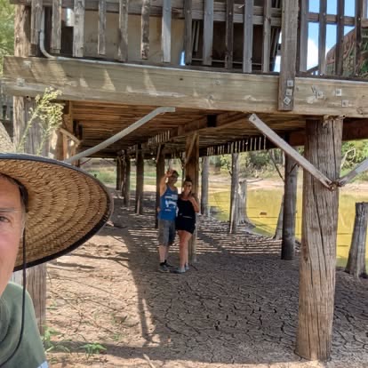 Volunteers beneath a reclaimed-wood deck while preparing the TwisterFest venue at Muscle Car Ranch